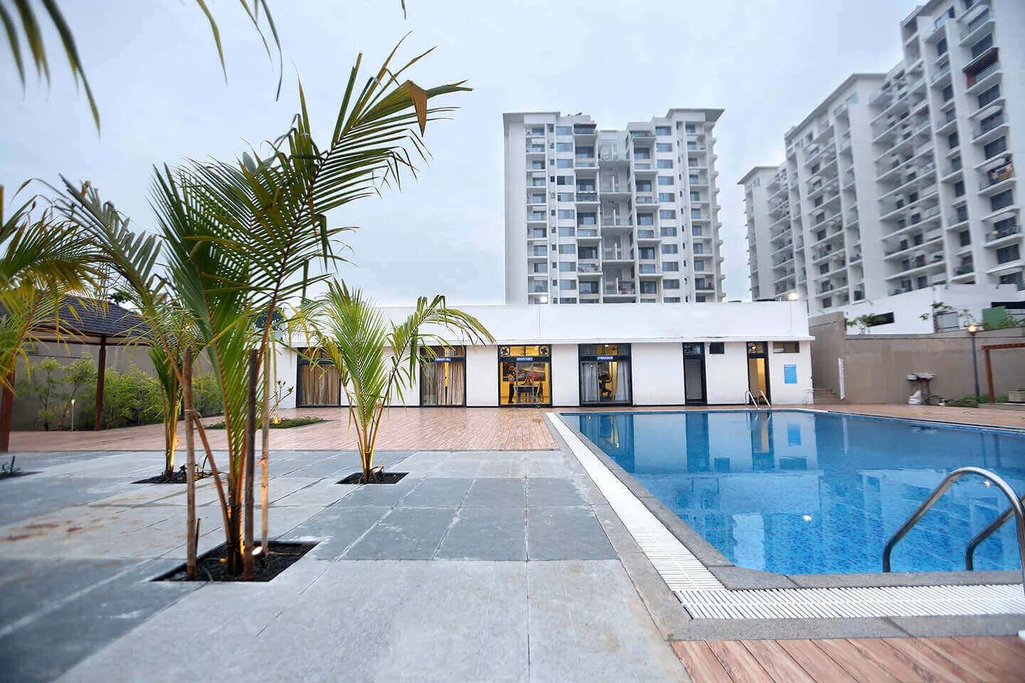 Swimming pool with the towers of L Axis, Moshi, Pune